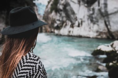 Nehre bakan şapkalı kadın.