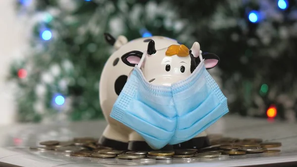 Piggy bank white bull in a mask. Christmas. 2021 new year. Year of the bull. Concept. Saving money as a way of life. Close-up