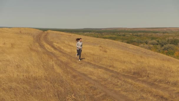 Egészséges gyönyörű lány részt vesz a fitness, kocogás az országban. edzés kocogás. Szabad fiatal nő fut nyáron parkban Jogger lány lélegzik friss levegőt — Stock videók