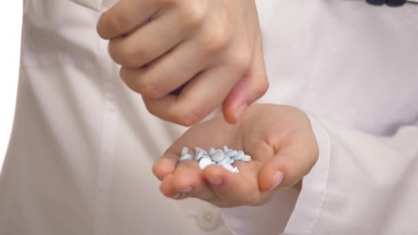 Close-up van de blanke dokters die blauwe pillen bij zijn vinger tellen. De jongeman plukt de tabletten op zijn handpalm. Er is een thema van drugsbehandeling. Begrip geneeskunde en gezondheidszorg — Stockvideo