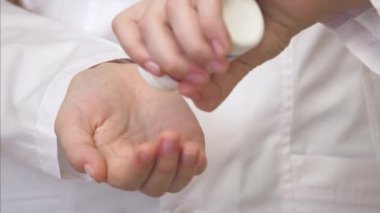 Parmaklarıyla mavi hapları sayan Kafkas doktorlarının eli. Genç adam avucundaki tabletleri topluyor. Bir uyuşturucu tedavisi teması var. Tıp ve sağlık hizmetleri kavramı