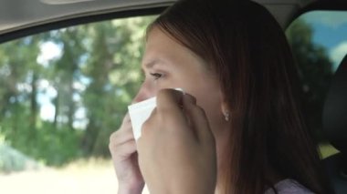 Güzel bir kız arabayla gider ve maske takar. Böylece etrafındaki insanlara Covid-19 bulaştırmaz. Enfeksiyon ve gribe karşı koruma. Yakın plan.