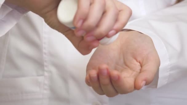 Close-up van de blanke dokters die blauwe pillen bij zijn vinger tellen. De jongeman plukt de tabletten op zijn handpalm. Er is een thema van drugsbehandeling. Begrip geneeskunde en gezondheidszorg — Stockvideo