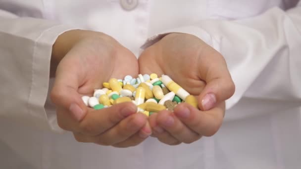 Beaucoup de pilules colorées dans les mains féminines d'un travailleur médical dans un manteau blanc. La médecine de la jeunesse éternelle et de la santé. Récupération des malades. Traitement des maladies. Gros plan — Video
