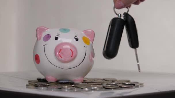 Das Sparschweingeschäft steht auf einem Haufen Münzen. Eine Hand steckt eine Münze in ein Lifestyle-Sparschwein auf gelbem Hintergrund. Geld zu sparen ist eine Investition in die Zukunft. Bankeninvestitionen. — Stockvideo