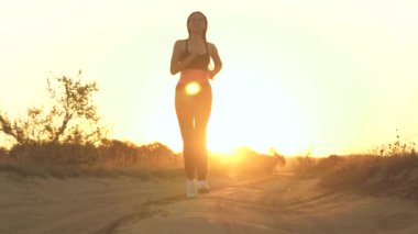 Parkta koşan kız spora gider. Koşucu atlet kız doğayla iç içe koşuyor. Yeşil Park 'ta sabah koşusu yapan bir kadın. Sağlıklı insanlar parkın aktif konseptini kullanır. Kız gün batımı silueti hayat tarzını yönetiyor