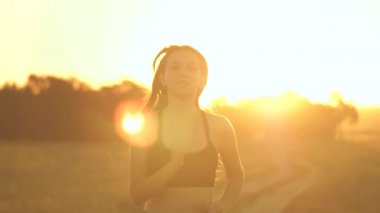 Parkta koşan kız spora gider. Koşucu atlet kız doğayla iç içe koşuyor. Yeşil Park 'ta sabah koşusu yapan bir kadın. Sağlıklı insanlar parkın aktif konseptini kullanır. Kız gün batımı silueti hayat tarzını yönetiyor