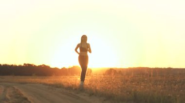 Parkta koşan kız spora gider. Koşucu atlet kız doğayla iç içe koşuyor. Yeşil Park 'ta sabah koşusu yapan bir kadın. Sağlıklı insanlar parkın aktif konseptini kullanır. Kız gün batımı silueti hayat tarzını yönetiyor