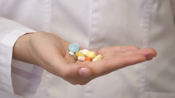 Πολύχρωμα χάπια στο χέρι. Κοντινό πλάνο. Ανακουφιστικά πόνου. Αντικαταθλιπτικά. Φάρμακα για έναν υγιεινό τρόπο ζωής. Ένας γιατρός με λευκό παλτό έγραψε μια συνταγή για πολλά φάρμακα. — Αρχείο Βίντεο