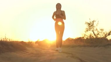 Parkta koşan kız spora gider. Koşucu atlet kız doğayla iç içe koşuyor. Yeşil Park 'ta sabah koşusu yapan bir kadın. Sağlıklı insanlar parkın aktif konseptini kullanır. Kız gün batımı silueti hayat tarzını yönetiyor