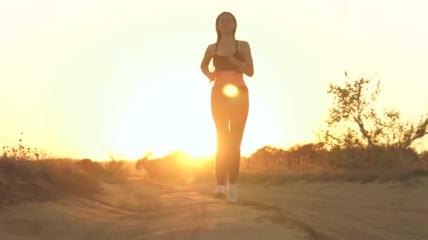 Parkta koşan kız spora gider. Koşucu atlet kız doğayla iç içe koşuyor. Yeşil Park 'ta sabah koşusu yapan bir kadın. Sağlıklı insanlar parkın aktif konseptini kullanır. Kız gün batımı silueti hayat tarzını yönetiyor — Stok video