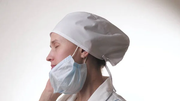 Уставший доктор снимает маску. Медицинский работник Медсестра в больнице. Защита от инфекций, бактерий, загрязнений. Фильтрация воздуха. Режим маски. Пандемия. — стоковое фото