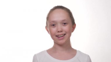 Dişinde tabağı olan genç bir kız gülümsüyor.