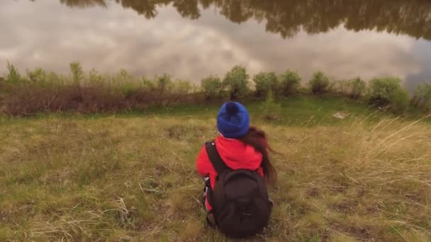 Het meisje zit op de berg met haar handen omhoog. — Stockvideo