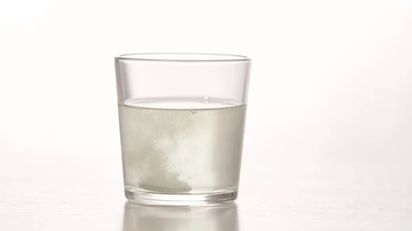Eine Brausetablette mit schmerzlindernder Wirkung wird in ein transparentes Glas Wasser geworfen. Medizinische, schnell wirkende Präparate für Gesundheit und Wohlbefinden. Leben auf Pillen — Stockfoto