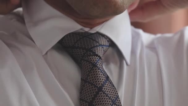 El hombre de negocios se pone una corbata en preparación para la mañana del día de trabajo. Código de vestimenta para todos los días. El estilo clásico de un hombre moderno de moda. Primer plano — Vídeos de Stock