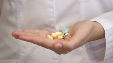 Beyaz önlüklü bir sağlık çalışanının elinde bir sürü renkli hap vardı. Ebedi gençliğin ve sağlığın ilacı. Hastaların iyileşmesi. Hastalıkların tedavisi. Yakın plan.