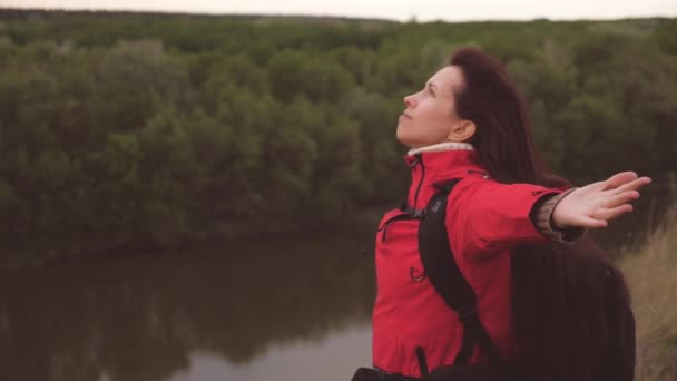 The girl breathes freely with her chest spreading her arms to the sides. Rest and relaxation while traveling. Hiking to stabilize breathing. Air inhalation for the health of the body. Research trips — Stock Video