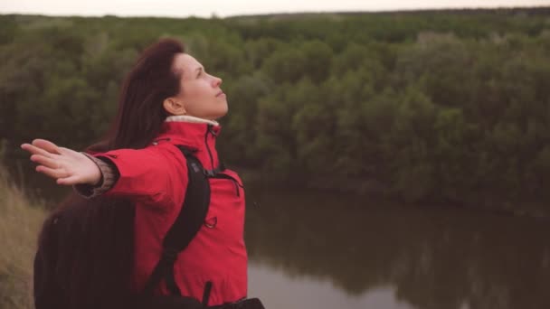 The girl breathes freely with her chest spreading her arms to the sides. Rest and relaxation while traveling. Hiking to stabilize breathing. Air inhalation for the health of the body. Research trips — Stock Video