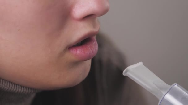 Dívka vdechuje roztok pro vdechnutí plic. Mladá žena v karanténě léčí kašel vdechováním páry lékem. Léčba člověka doma s profesionálním vybavením pro nachlazení — Stock video