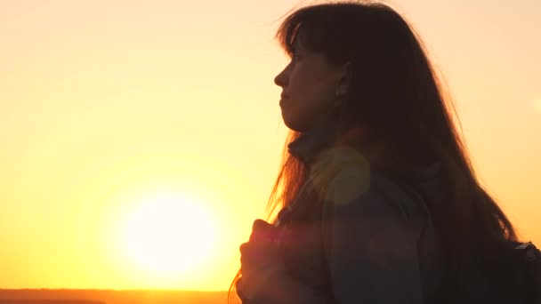 Ragazza viaggiatore con uno zaino al tramonto guarda nel cielo e prega. Una donna sogna una vita meravigliosa. Avventuriero in escursioni nella foresta. Passeggiate nel parco nel fine settimana — Video Stock