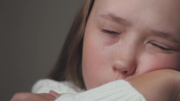 A teenage child cries and tears run down her cheeks. The girl is upset due to hormonal changes in the body. Childrens nervousness from problems with peers and parents. Lifestyle soul cry. Fear and — Stock Video