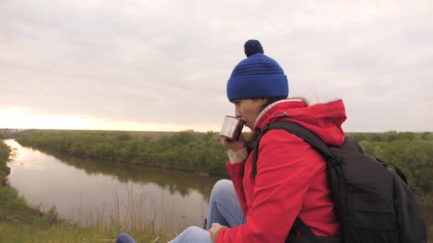 La jeune fille boit le thé d'une tasse assise sur une haute montagne et profitant de la nature dans le parc. Femme voyageur à la recherche d'aventure. Détendez-vous pendant la randonnée. Randonnées longue distance. Explorateur humain de — Video