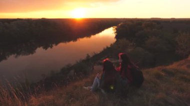 Dişi gezginler dağın tepesinde oturur ve gün batımını seyreden bir fincanda çay içerler. Birlikte yeni yerler fethedeceğiz. Aktif hafta sonu tatili. Özgür kadın turistler hayatta macera arıyorlar.