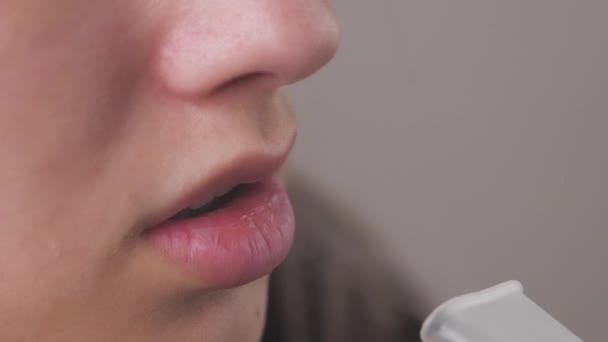 Gözlüklü kadın astım spreyini kullanıyor ve derin nefes alıyor. Nebuliser kullanan kızın portresi. Tedavide tıbbi araçların kullanılması teması. — Stok video