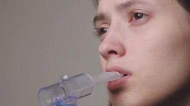 Adam öksürük, grip ve soğuk algınlığını tedavi etmek için nebulizörle derin nefes alıyor. Genç bir kıza bronşiyal astım ya da alerji ilacı veriliyor. Ergen, hastalığı evde kendi başına tedavi ediyor.