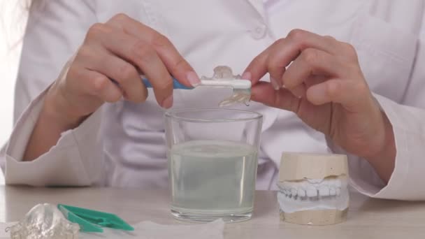 Lekarz ortodonta pokazuje, jak prawidłowo myć talerze dzieci szczoteczką do zębów. Nowoczesne technologie w klinikach stomatologicznych do prawidłowego gryzienia u młodzieży. Za piękny, zdrowy uśmiech, a nawet dziecko. — Wideo stockowe