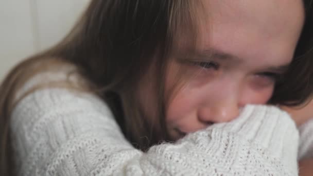 A teenage child cries and tears run down her cheeks. The girl is upset due to hormonal changes in the body. Childrens nervousness from problems with peers and parents. Lifestyle soul cry. Fear and — Stock Video