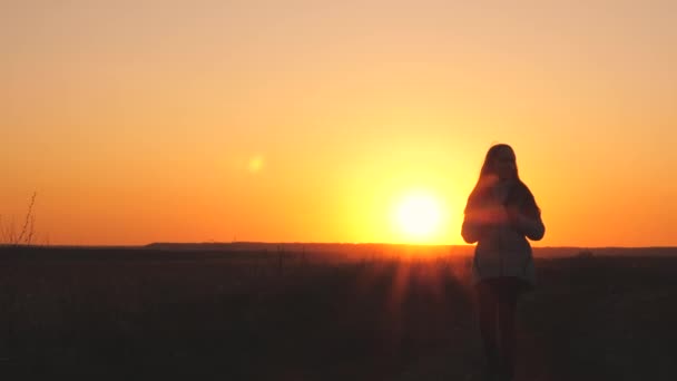 Una ragazza viaggiatrice cammina con uno zaino sulla schiena e sorride al tramonto nel cielo. Un adolescente in campeggio in vacanza. Infanzia in cerca di avventura dalla mattina all'alba. L'amore per il — Video Stock