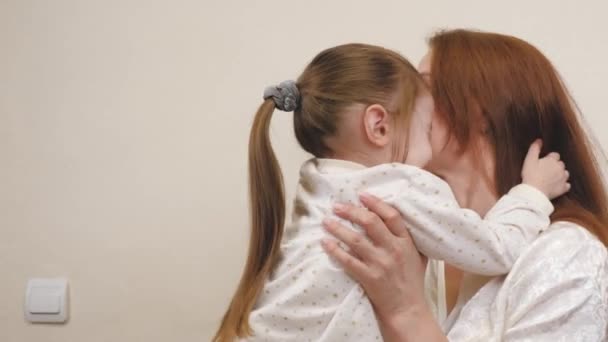 Little child hugs mom and laughs. Happy girl rejoices at mommy. A daughter and a woman are playing in the childrens room. Parents love for kid. Upbringing on maternity leave. Family life — Stock Video