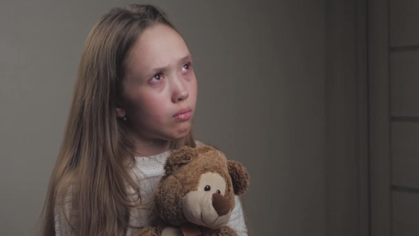 Triest klein meisje biddend terwijl ze een teddybeer in haar handen houdt. De tiener zoekt bescherming van God. Een eenzaam kind met speelgoed in zijn hand wil gelukkig zijn. Spirituele religie van een toegewijd persoon — Stockvideo