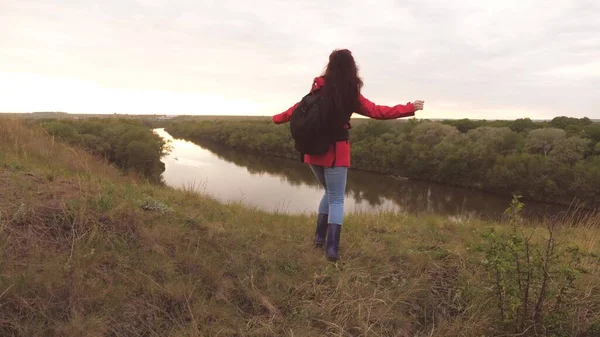 Happy girl reiziger met een rugzak danst en belt vrienden. Vrolijk meisje toerist is op zoek naar avontuur. Toeristische uitstapjes. Een leuke manier van leven. Het leven is interessant en vermakelijk. Rust uit in de natuur — Stockfoto