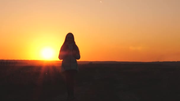 Een meidenreiziger loopt met een rugzak op haar rug en glimlacht bij zonsondergang in de lucht. Een tiener op kampeervakantie. Jeugd op zoek naar avontuur van 's ochtends tot' s morgens vroeg. Liefde voor de — Stockvideo