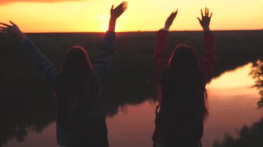 Mutlu kız gezginler şafak vakti sırt çantalarıyla dağa atlayıp ellerini çırpıyorlar. Kadınlar takımında neşeli turist gezileri var. Macera haftası. Takım çalışması. En iyi şekilde