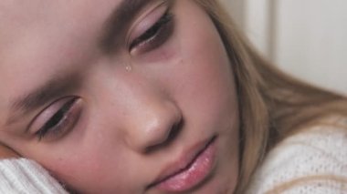 Genç bir çocuk ağlıyor ve gözyaşları yanaklarından akıyor. Kız, vücuttaki hormonal değişimlerden dolayı üzgün. Akranlar ve ebeveynlerle olan sorunlardan dolayı çocukların gerginliği. Yaşam tarzı ruh ağlaması. Korku ve