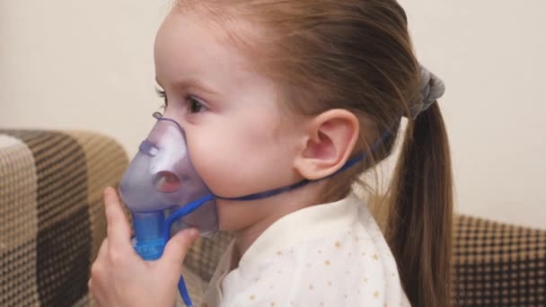 Roztomilé dítě v masce dýchá přes inhalátor. Domácí inhalační procedura. Dítě dostává respirační terapii s rozprašovačem. Léčte své dítě na koronavirus doma. Malé dítě. — Stock video