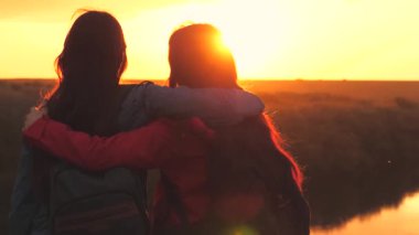 Kızlar gün batımında elleri ile bir nesneye bakarlar yüksek bir dağda dururken, aktif bir aile seyahati sırasında, bilinmeyen bir yerde adrenalin patlaması, şafakta bir dinlenme alanına yürüyüş.