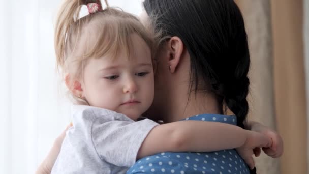 Un petit enfant étreint la mère par le cou et se calme, l'humeur des enfants devient meilleure à côté de la mère, la communication entre le parent et le bébé pour la compréhension et l'amour, la nounou fait face — Video