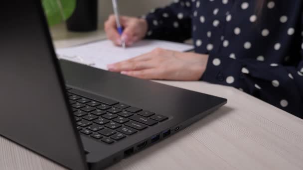Бізнес-леді друкує документ на ноутбуці і записує записи в планшеті, роботу офісного працівника в офісі за комп'ютером на столі, дівчина заповнює заявку на роботу, веде облік — стокове відео