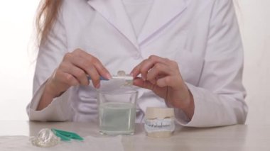 Doktor ortodontist çocuk tabaklarını diş fırçasıyla nasıl düzgün yıkayacağını gösteriyor. Diş kliniklerindeki modern teknolojiler ergenlerde ısırıkları düzeltmek için kullanılıyor. Güzel, sağlıklı bir gülümseme ve hatta bir çocuk için