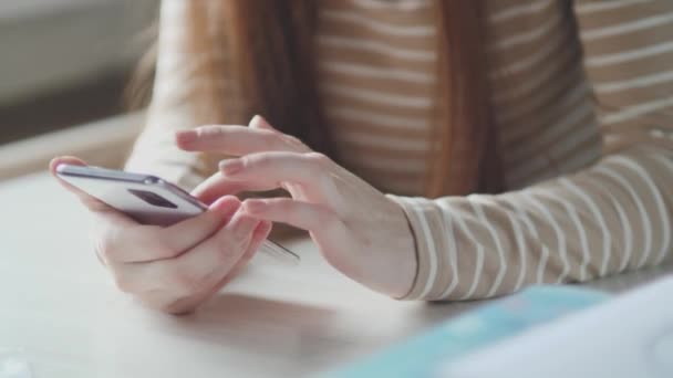 Closeup femeie de afaceri tastarea mesaj pe telefonul mobil la birou acasă, fată tânără chat la telefon. Închideți mâinile femeilor tinere folosind smartphone-ul — Videoclip de stoc