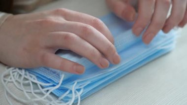 Kadın birçok koruyucu solunum maskesini, ekipmanları elinde tutuyor, hava hastalıklarına karşı sigorta yaptırıyor, covid-19, grip, koronavirüs, erkek için cerrahi maskeler.