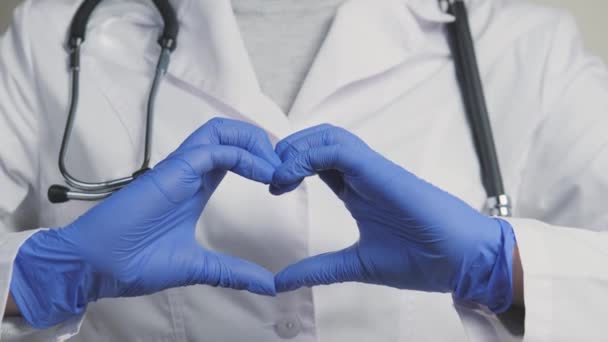 Lekarz w niebieskich rękawiczkach pokazuje swoje serce, cordiologist dla zdrowego odpływu krwi, usługi terapeuty w szpitalach z najlepszych specjalistów, jego czas, aby zbadać ciało na — Wideo stockowe