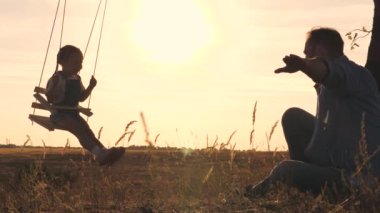 Bir baba, küçük bir çocuğu salıncakta sallıyor yaz parkında gün batımında gökyüzünde, bir kız havada süzülüyor kolları açık ve uçmayı hayal ediyor, bir çocuk babasıyla, kızıyla bir uçakla oynuyor.