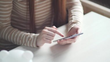 Kapalı bir iş kadını ev telefonunda mesaj yazıyor, genç bir kız telefonda sohbet ediyor. Akıllı telefon kullanarak genç kadın ellerini kapat.