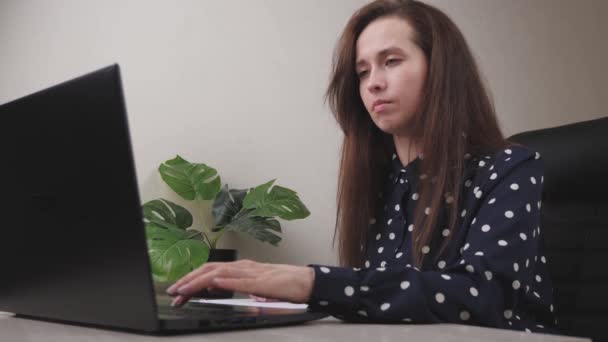 Een zakenvrouw werkt op een computer in het kantoor, een freelancer typt tekst op het toetsenbord, online in een programma op afstand, het internet voor gegevensoverdracht, een meisje vult in en onderhoudt belangrijke — Stockvideo